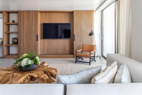 a living room with a couch and a tv at Four Seasons Astir Palace Hotel Athens in Athens
