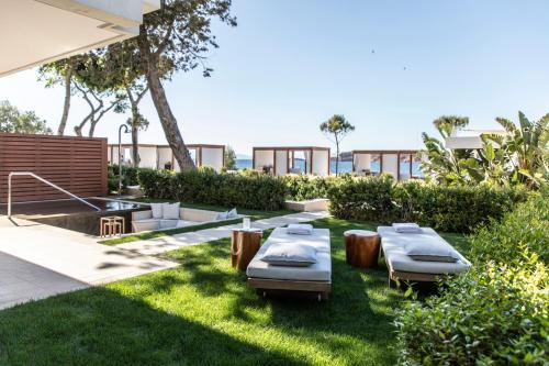 a garden with beds and tables in the grass at Four Seasons Astir Palace Hotel Athens in Athens