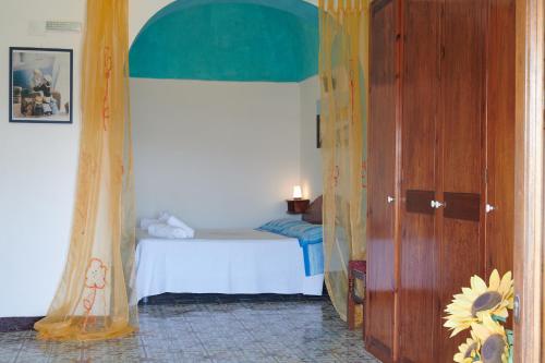 パンテレリアにあるDammuso Girasole Blu VISTA MAREのベッドルーム1室(ベッド1台付)、窓付きのドアが備わります。