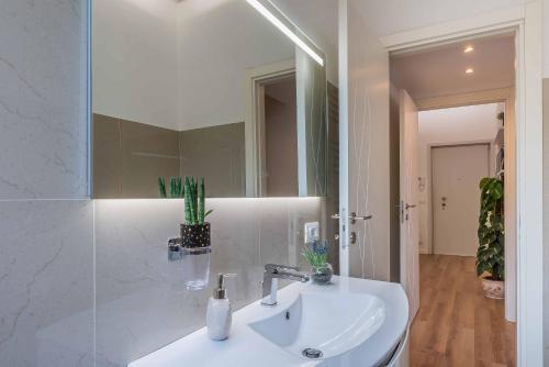 Baño blanco con lavabo y espejo en Luxury apartment Malpensa, en Cardano al Campo