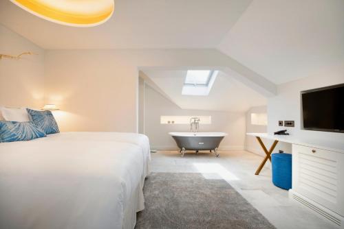 a bedroom with a bed and a bath tub and a television at Riva Marina Hvar Hotel in Hvar