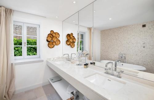 a bathroom with a sink and a mirror at Riva Marina Hvar Hotel - New in June 2022 in Hvar