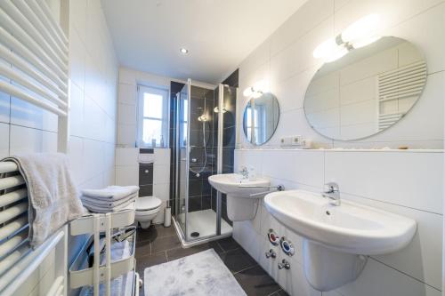 a white bathroom with a sink and a mirror at Leuchtturmhaus 1888 EG Wohnung in Borkum