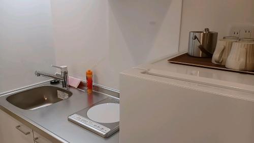 a kitchen counter top with a sink and a counter top at Living Inn Nahakoumae in Naha