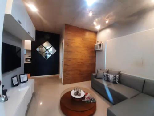 ein Wohnzimmer mit einem Sofa und einem Tisch in der Unterkunft MC residence 5 w/ Netflix,100Mbps Wifi, hot shower in General Santos