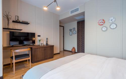 a bedroom with a bed and a desk and a television at Giuaani Winery in Manavi