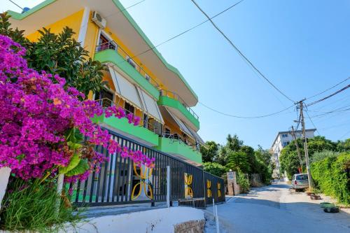a building with purple flowers on the side of it at Vila Lida in Sarandë