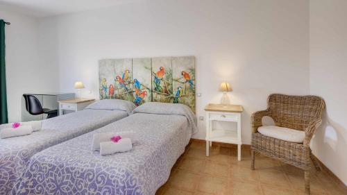 pokój hotelowy z dwoma łóżkami i krzesłem w obiekcie Villa Vulcano by Calima Villas w mieście Costa de Antigua