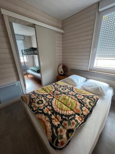 une chambre avec un lit avec une couette dessus dans l'établissement APPARTEMENT 4 PERSONNES CLASSE 2 ETOILES LEBOUCQ Laurent, à Fort-Mahon-Plage