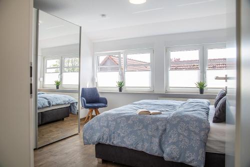 ein Schlafzimmer mit zwei Betten und einem Spiegel in der Unterkunft 50137 "Deichkajüte 6" in Carolinensiel