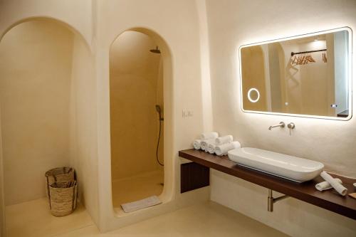 a bathroom with a sink and a shower at Azalea Houses Cave Villa in Oia