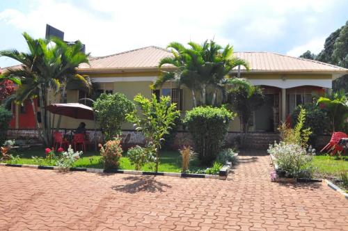 una casa con palmeras y una entrada de ladrillo en The Roots classic hotel, en Njeru