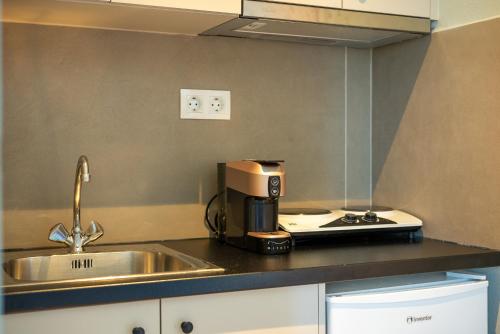 a kitchen counter with a coffee maker and a sink at Serenity Hideaway in Palaiochora