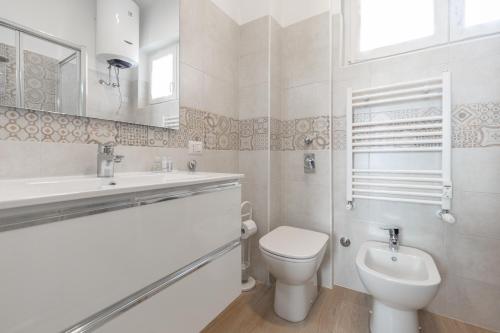 bagno bianco con servizi igienici e lavandino di Appartamento Ripa Milano a Milano
