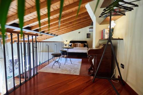 a room with a bed and a table and a piano at Luxury Design Loft - Piazza Pontida in Bergamo