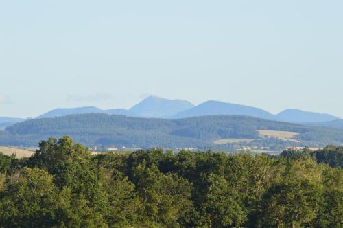 un grupo de montañas en la distancia con árboles en Chambres d'hôtes La Ganivelle, en Servant