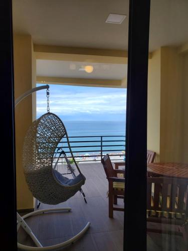 a swing on a balcony with a view of the ocean at Beach House Gonio in Batumi