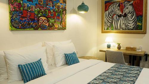a bedroom with a bed and a painting on the wall at Roka Resort by ARKasia Foundation in Berakit