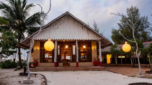 a house with two large yellow lanterns in front of it at Roka Resort by ARKasia Foundation in Berakit