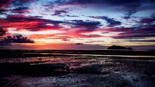 a sunset on the beach with a red sky at Roka Resort by ARKasia Foundation in Berakit