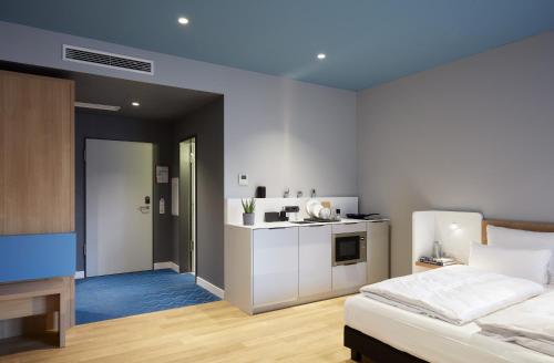 a bedroom with a bed and a small kitchen at about:berlin Hotel in Berlin
