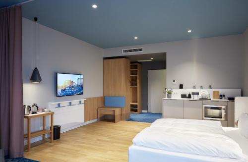 a bedroom with a television and a refrigerator at about:berlin Hotel in Berlin