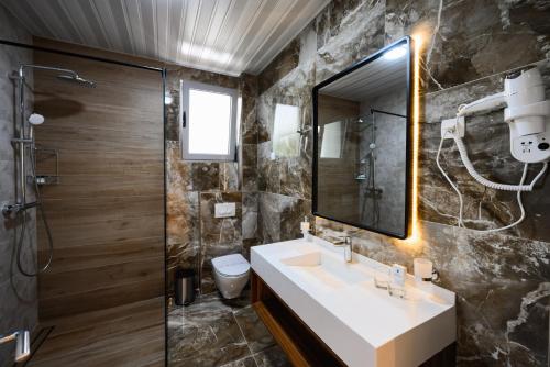 La salle de bains est pourvue d'un lavabo et d'une douche. dans l'établissement G Star Hotel, à Sutomore