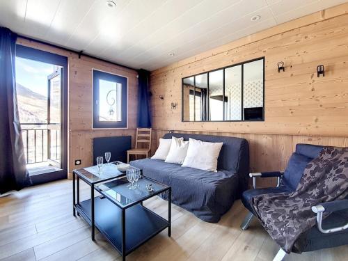 un salon avec un canapé bleu et une table dans l'établissement 2P rénové près pistes, balcon, parking extérieur - FR-1-344-687, aux Menuires