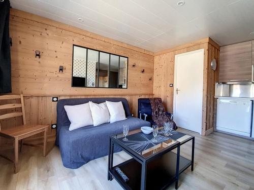 un salon avec un canapé bleu et une table dans l'établissement 2P rénové près pistes, balcon, parking extérieur - FR-1-344-687, aux Menuires