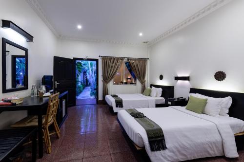 Habitación de hotel con 2 camas y escritorio en The Oasis Harbor, en Siem Reap