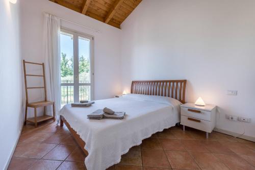 a bedroom with a bed and a chair and a window at Il Gelsomino in Manerba del Garda