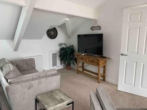 a living room with a couch and a television at Lovely 2 bedroom modern loft apartment sea view in Morecambe