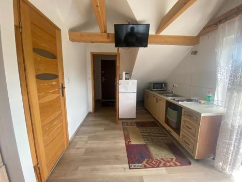 a kitchen with a refrigerator and a tv on the ceiling at Zajazd Tadeo in Pietrzykowice
