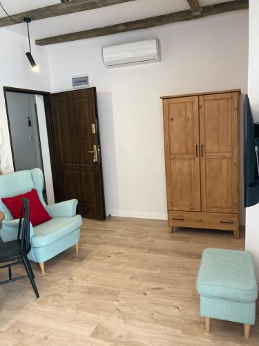 a living room with a couch and a cabinet at Przy Poznańskiej Bramie in Inowrocław