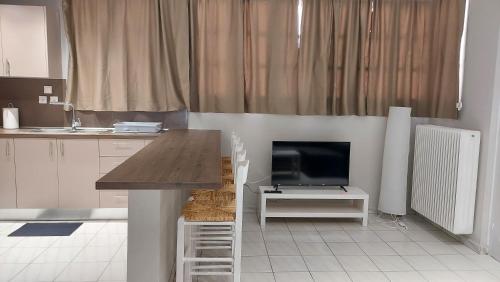 a kitchen with a table and a tv in a room at Aphrodite goddess in Artemida