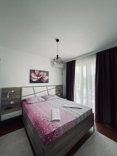 a bedroom with a bed with a pink comforter at Casa Nita in Ulcinj