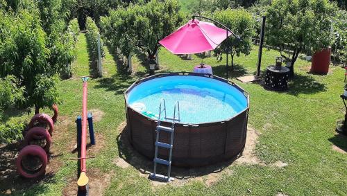 bañera de hidromasaje con sombrilla rosa junto a un patio en Apartment Amigo, en Sirova Katalena