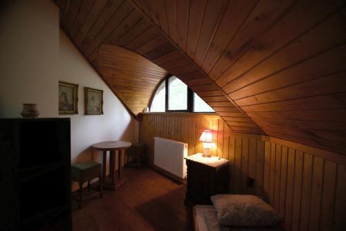 an attic room with a wooden ceiling and a lamp at Hideout Homestead on the riverside Fishing&Hunting in Mezőtúr