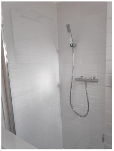 La salle de bains blanche est pourvue d'une douche. dans l'établissement Adorable Tiny House pour savourer la Provence, à Éguilles