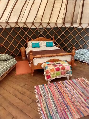 a room with two beds and a rug in a yurt at South Downs Eco Lodge & Camping in East Meon