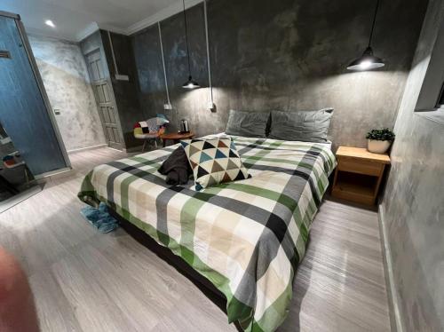 a bedroom with a bed with a green and white blanket at YY Residences in Ipoh
