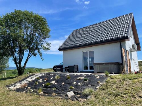 a house on a hill with a gravel driveway at Domek nad Stawem in Kłodzko