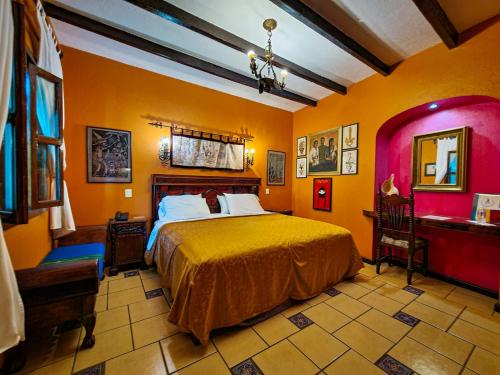 a bedroom with a large bed and orange walls at Hotel Boutique Casona Maya Mexicana in Tapachula