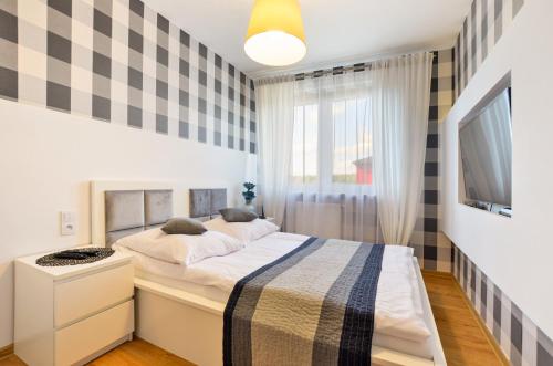 a small bedroom with a bed and a tv at Apartament 14 in Zwierzyniec