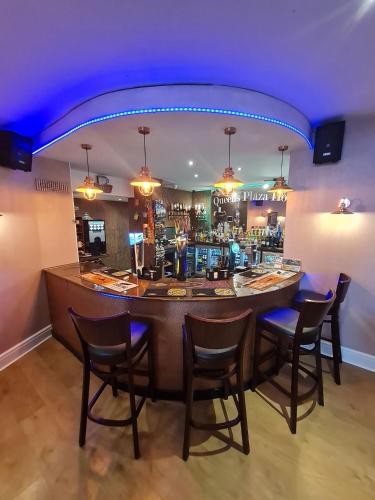a bar in a restaurant with chairs around it at Queens Plaza Hotel in Blackpool