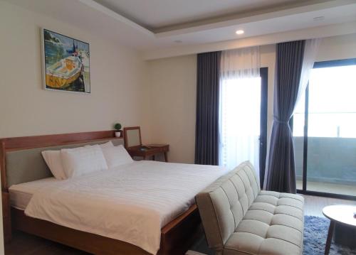 um quarto com uma cama, um sofá e uma janela em FLC Sea Tower Quy Nhơn - VIP HOUSE em Quy Nhon
