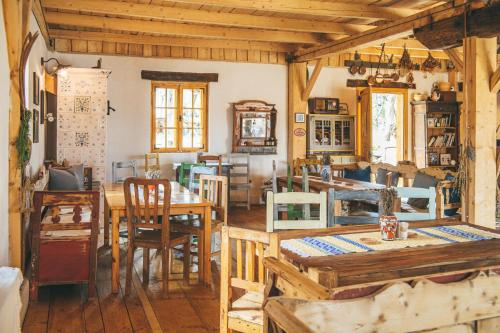 a dining room with wooden tables and chairs at Viscri 32 - White Barn and Blue House in Viscri