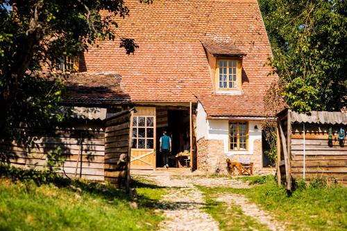 a man standing in the doorway of a house at Viscri 32 - White Barn and Blue House in Viscri