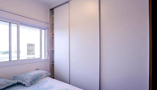 Apartamento inteiro para hospedagem في ساو باولو: غرفة نوم مع خزانة كبيرة وسرير مع الوسائد