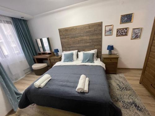 una camera da letto con un grande letto con due asciugamani di Апартамент Стил a Chepelare